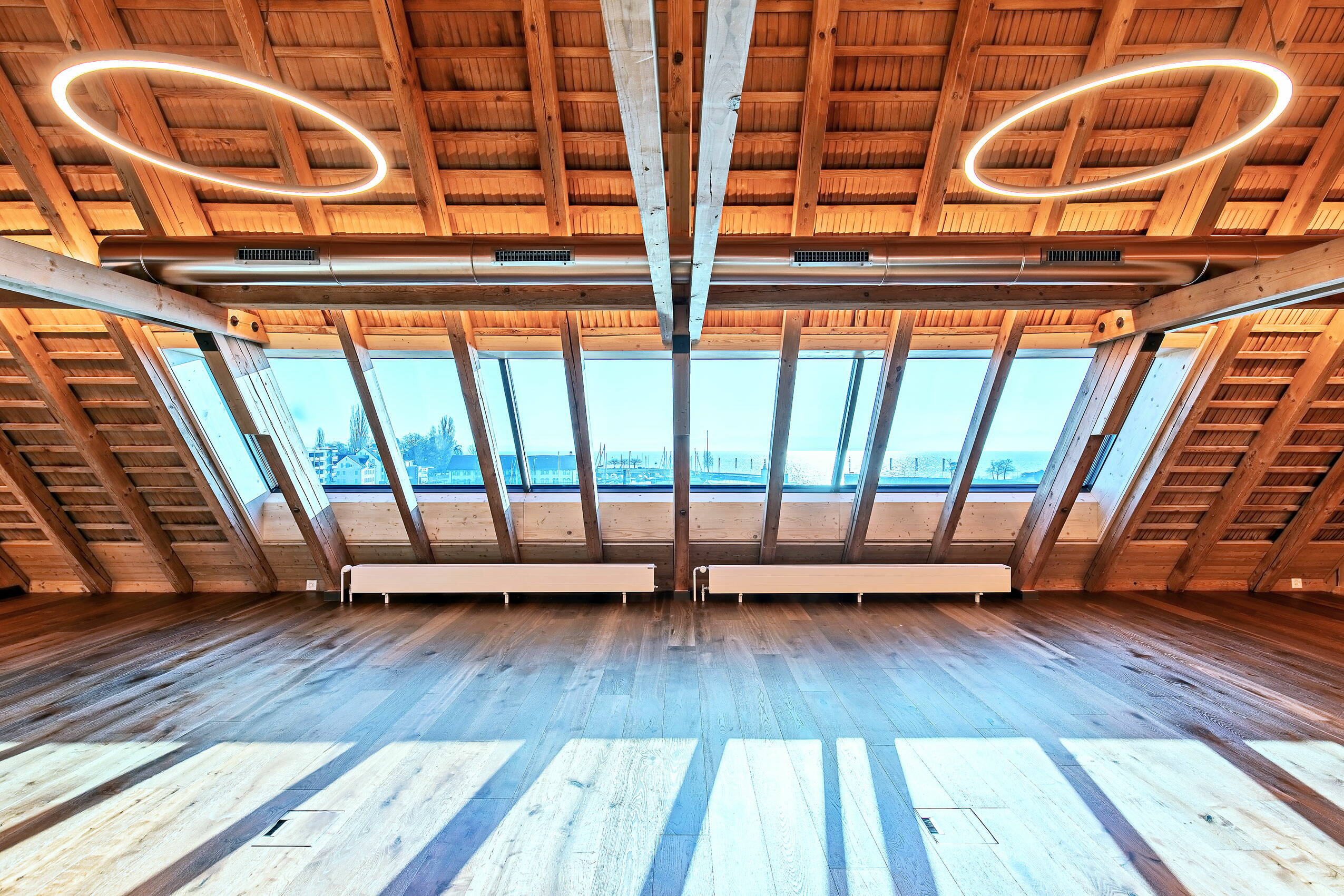 Zoom: Licht fällt durch die grosszügigen modernen Fenster in einer Dachschräge im Dachstock eines Altbaus.