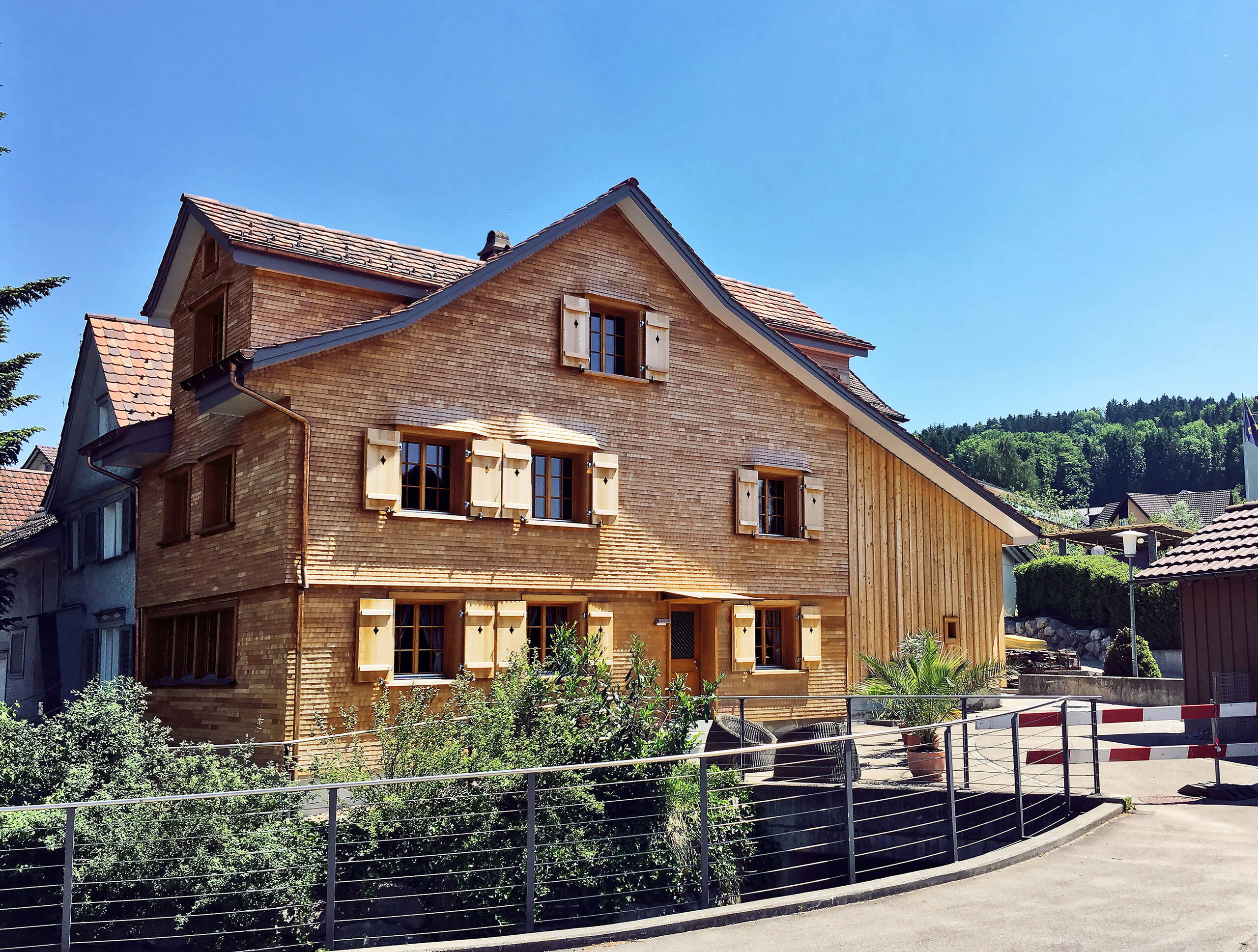 Nach der Renovation: der Anbau rechts wird in der Fassadengestaltung wieder erkennbar, die Fensterverdachungen sind wieder ausgebildet. Schindelschirm, Fensterfutter, Jalousieläden und Leistenschirm sind in Lärche gefertigt.