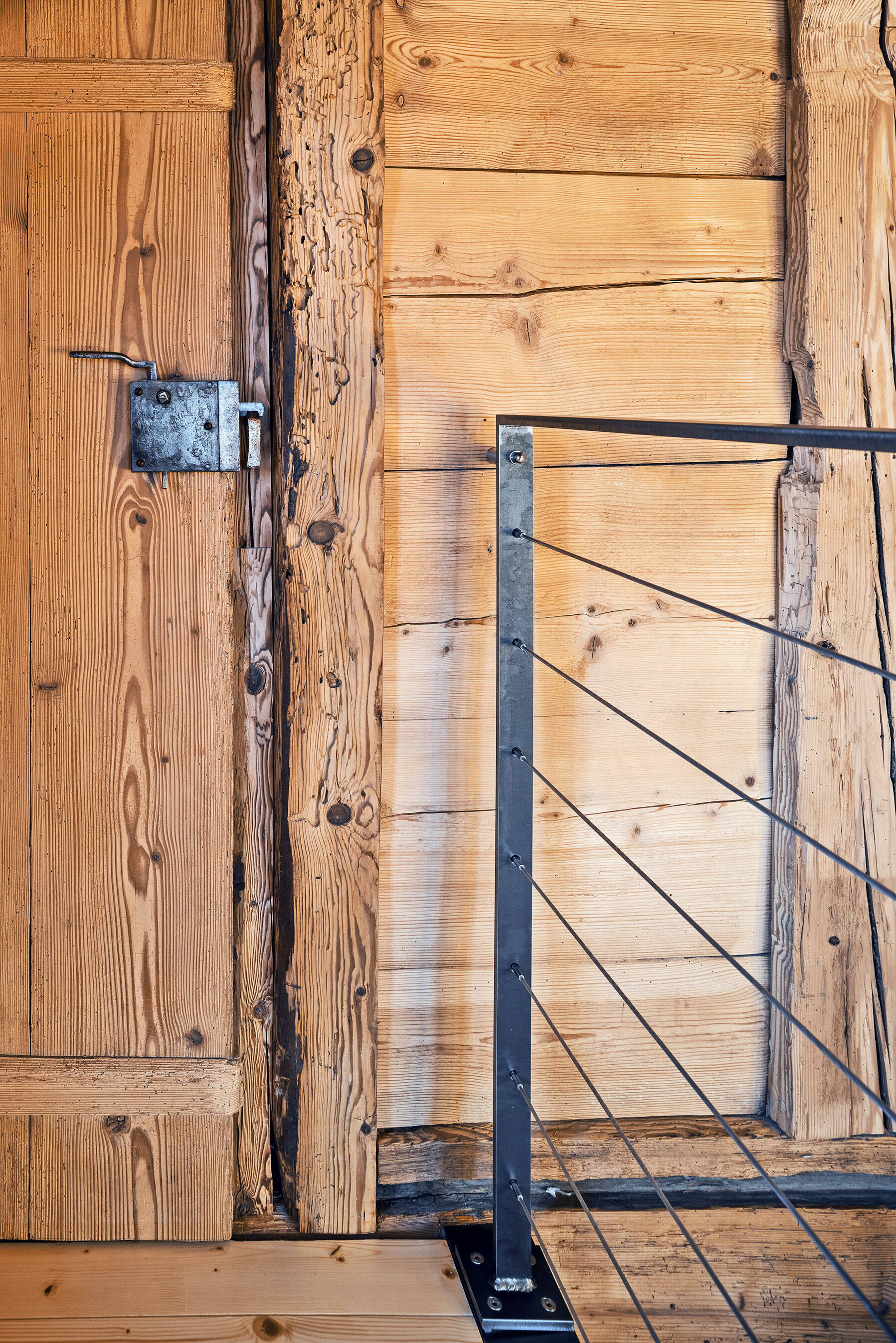 Holzbohlenständerwand mit alter Türe im Galeriegeschoss.